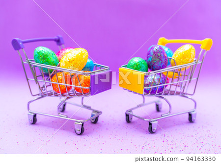 Happy Easter background. Easter eggs are colorful in a shopping basket on purple paper. Holiday concept. Copy space for text. 94163330