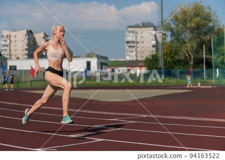 Young woman running on the running track Young woman running on the running track 94163522