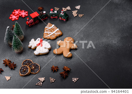 Elements of Christmas decorations, sweets and gingerbread on a wooden cutting board Elements of Christmas decorations, sweets and gingerbread on a wooden cutting board 94164401