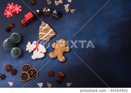 Elements of Christmas decorations, sweets and gingerbread on a wooden cutting board 94164402