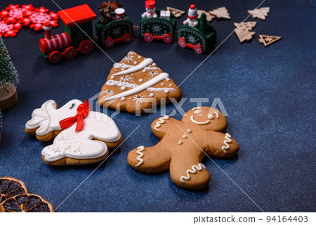 Elements of Christmas decorations, sweets and gingerbread on a wooden cutting board Elements of Christmas decorations, sweets and gingerbread on a wooden cutting board 94164403