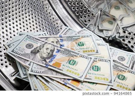 Close-up of washing dollars in machine, money laundering, financial fraud concept Close-up of washing dollars in machine, money laundering, financial fraud concept 94164865