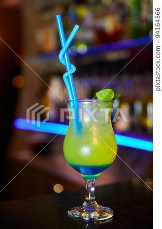 Multicolored alcoholic cocktail with mint leaves on the bar counter Multicolored alcoholic cocktail with mint leaves on the bar counter 94164866