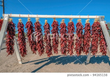 Hanging long dried red chili peppers for sale in Tucson, Arizona Hanging long dried red chili peppers for sale in Tucson, Arizona 94165138