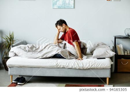 Exhausted man waking up in the morning Exhausted man waking up in the morning 94165305