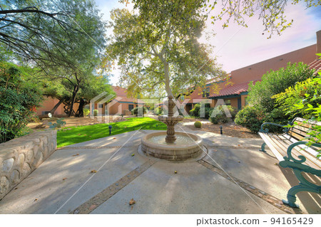 Subdivision in Tucson, Arizona with small fountain and wooden bench outside the houses Subdivision in Tucson, Arizona with small fountain and wooden bench outside the houses 94165429