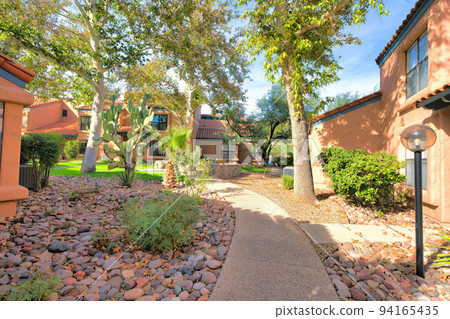 Concrete walkway in the middle of houses with italianate designs in Tucson, Arizona Concrete walkway in the middle of houses with italianate designs in Tucson, Arizona 94165435