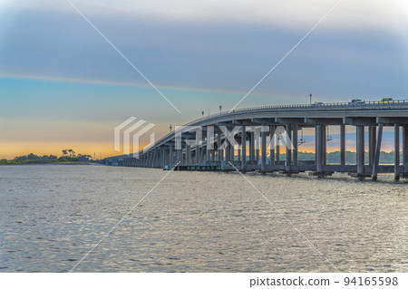 Destin Bridge over the sea against the sunset sky at Destin, Florida 94165598