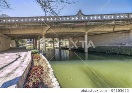 Downtown San Antonio, Texas- River walk concrete path under a bridge with decorative barriers 94165633