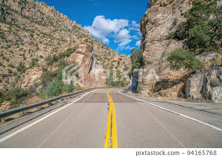 Mount Lemmon, Arizona- Highway with metal barriers in between the rocky mountain walls 94165768