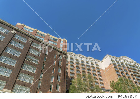 Looking up at apartment buildings against blue sky in San Antonio Texas 94165817