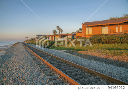 Railroad and beach houses on a cliff at Del Mar Southern California at sunset. Railroad and beach houses on a cliff at Del Mar Southern California at sunset. 94166012