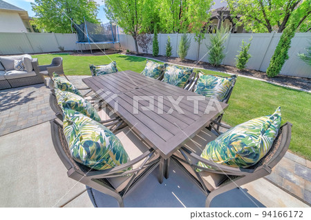 Table and chairs for outdoor eating and dining at the patio of a house Table and chairs for outdoor eating and dining at the patio of a house 94166172
