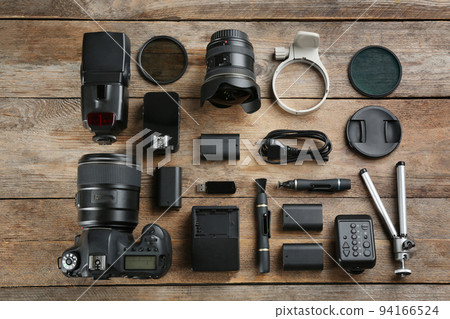 Flat lay composition with equipment for professional photographer on wooden table 94166524
