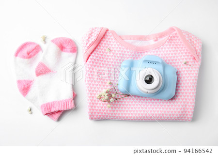 Composition with toy camera and children's clothes on white background, top view. Future photographer 94166542