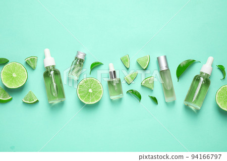 Flat lay composition with lime essential oil on light turquoise background Flat lay composition with lime essential oil on light turquoise background 94166797
