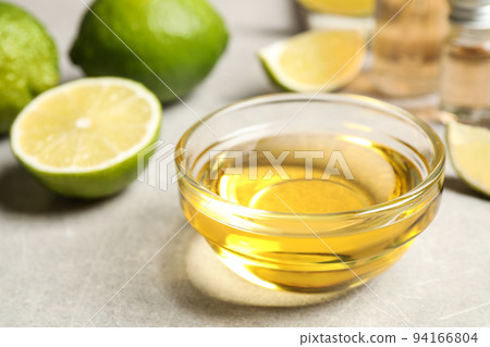 Lime essential oil in bowl on light table Lime essential oil in bowl on light table 94166804