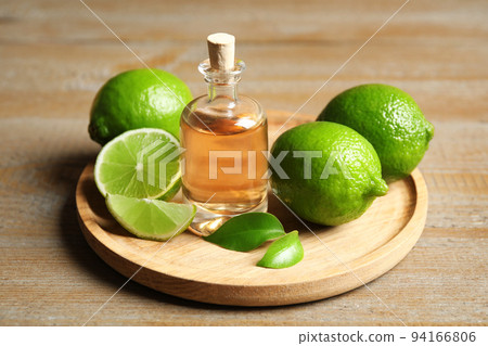 Lime essential oil and citrus fruits on wooden table Lime essential oil and citrus fruits on wooden table 94166806