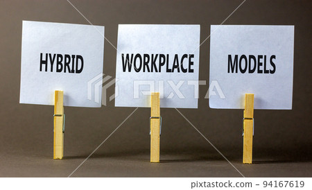 Hybrid workplace models and support symbol. Concept words Hybrid workplace models on white paper on clothespins. Beautiful grey background. Business Hybrid workplace models quote concept. Copy space 94167619