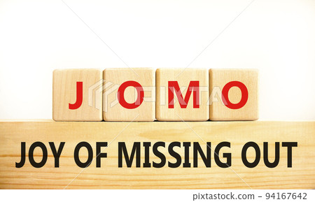 JOMO joy of missing out symbol. Concept words JOMO joy of missing out on wooden blocks on a beautiful white background. Business JOMO joy of missing out concept. Copy space. 94167642