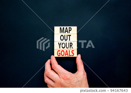 Support and map out your goals symbol. Concept words Map out your goals on wooden blocks on beautiful black table black background. Businessman hand. Business, support and map out your goals concept Support and map out your goals symbol. Concept words Map out your goals on wooden blocks on beautiful black table black background. Businessman hand. Business, support and map out your goals concept 94167643