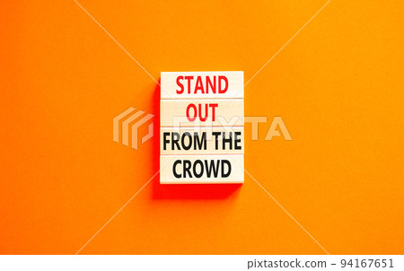 Stand out from the crowd symbol. Concept words Stand out from the crowd on wooden blocks on a beautiful orange table orange background. Business, stand out from the crowd concept 94167651