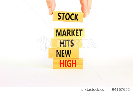 Stock market hits new high symbol. Concept words Stock market hits new high on wooden blocks on a beautiful white background. Businessman hand. Business stock market hits new high concept. Copy space 94167663