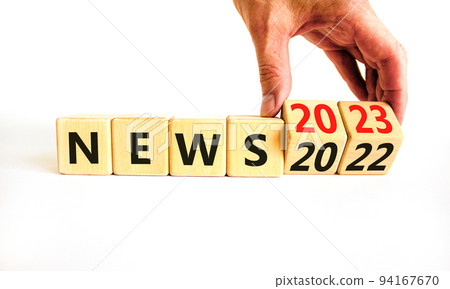 2023 News new year symbol. Businessman turns a wooden cube and changes words News 2022 to News 2023. Beautiful white table white background, copy space. Business 2022 news new year concept. 2023 News new year symbol. Businessman turns a wooden cube and changes words News 2022 to News 2023. Beautiful white table white background, copy space. Business 2022 news new year concept. 94167670