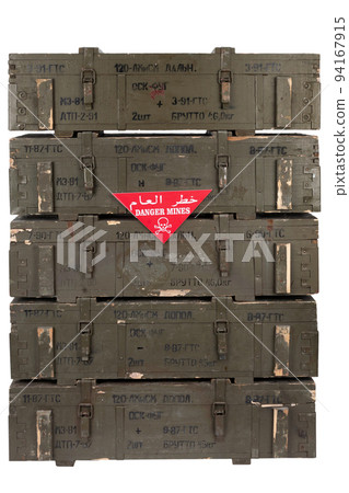 Arabic/English minefield warning red sign - Danger Mines on soviet army ammunition stack of green crates. Text on crates in russian - type of ammunition, projectile caliber, projectile type, number of 94167915