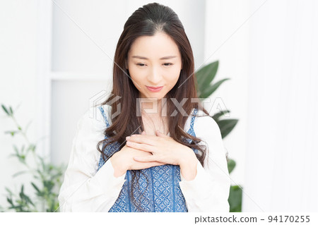 A woman holding her hand on her chest 94170255