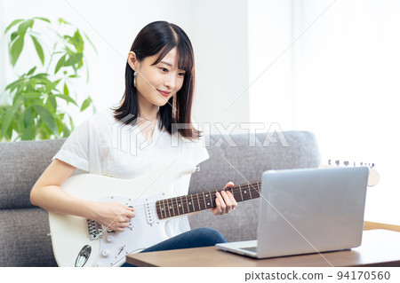 一邊看電腦一邊彈吉他的女人 一邊看電腦一邊彈吉他的女人 94170560