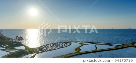 夕陽照耀下的日本海和千枚田白米在水稻種植期間的全景@石川能登半島 夕陽照耀下的日本海和千枚田白米在水稻種植期間的全景@石川能登半島 94170759