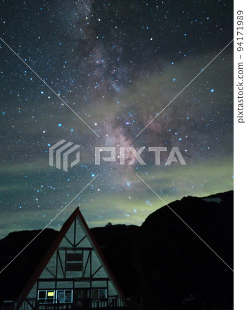 Mt. Norikura in summer Tatamidaira parking lot and building with triangular roof under the starry sky 94171989