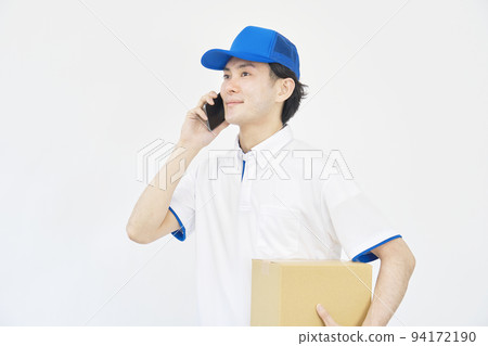 A man of a courier who makes a phone call with a smartphone on a white background 94172190
