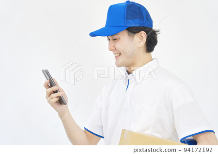 A man of a courier looking at a smartphone on a white background 94172192