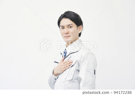 Portrait of a worker standing on a white background looking at the camera 94172286