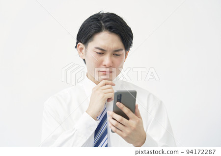 Businessman having trouble holding a smartphone on a white background 94172287