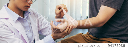 Asian physiotherapists are examining the results of wrist surgery of patients. 94172986