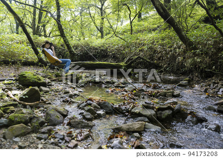 Children chairing along the mountain stream 94173208