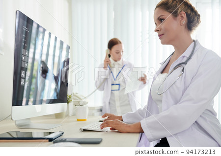 Female scientist working on medical reseach on computer at her desk, analyzing data and making report 94173213
