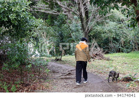 走在森林公園的法國鬥牛犬和所有者 走在森林公園的法國鬥牛犬和所有者 94174041