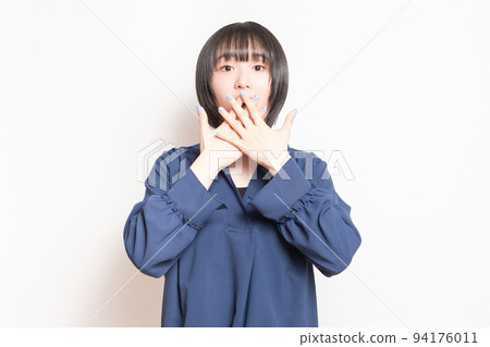 A young woman doing a surprised pose in front of a white background 94176011