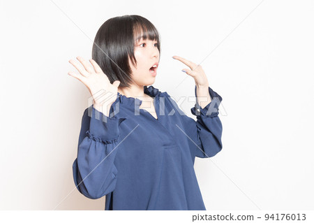 一個年輕女子在白色背景前擺出驚訝的姿勢 一個年輕女子在白色背景前擺出驚訝的姿勢 94176013