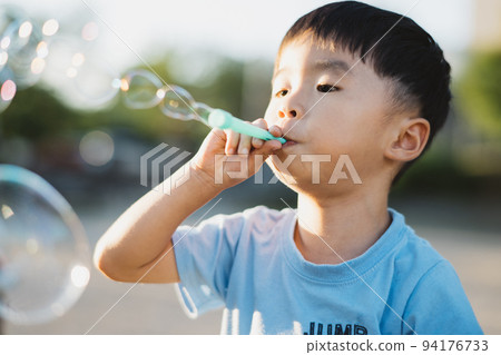 Boys playing with soap bubbles Boys playing with soap bubbles 94176733