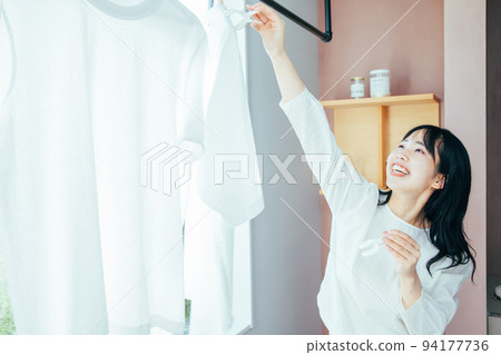 A woman hanging out the laundry Washing 94177736