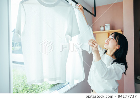 A woman hanging out the laundry Washing 94177737