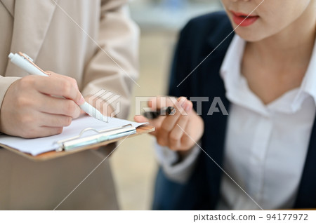 Two Asian businesswomen working and planning a project together. cropped Two Asian businesswomen working and planning a project together. cropped 94177972