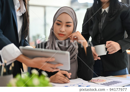 Professional Asian Muslim businesswoman pensive thinking a business plan with her coworker. 94177977