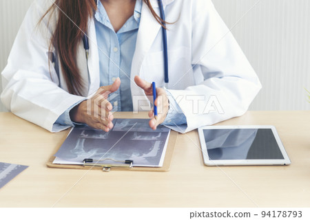 Close up hands of women doctor write prescription medical lab hospital. Crop asian women hand doctors working in medical clinic looking CAT scan xray film. Doctor with stethoscope writing on notepad 94178793
