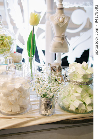 Wedding candy bar with white flowers in rustic style Wedding candy bar with white flowers in rustic style 94179692